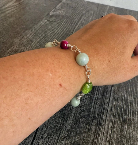 Bracelet with multicolored beads on a wrist against a wooden surface