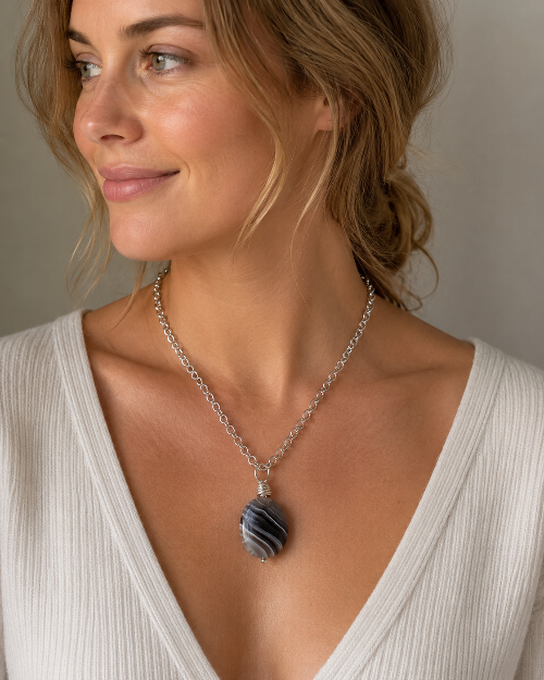 Woman wearing a necklace with a pendant against a neutral background