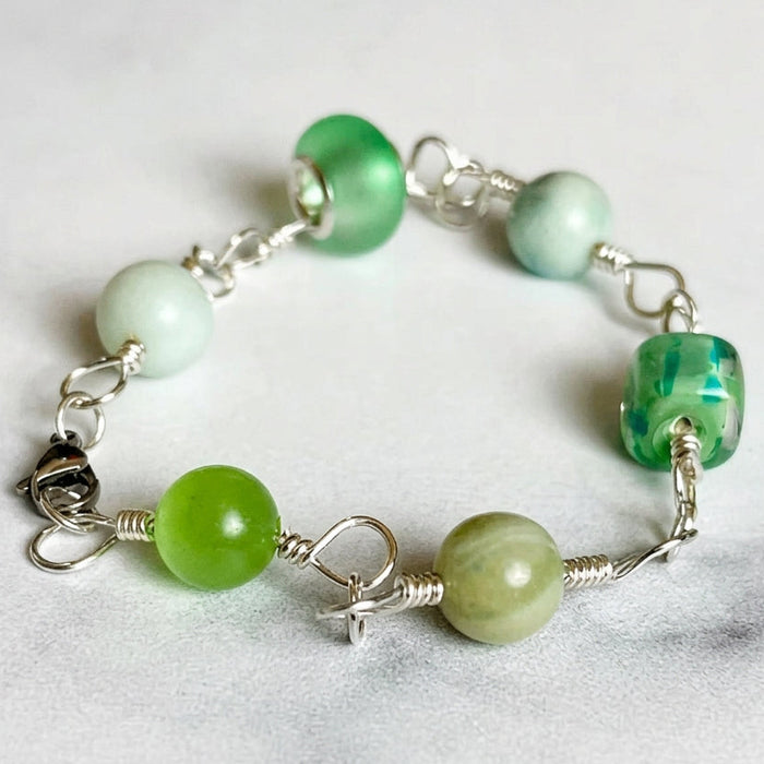 Green beaded bracelet on a marble surface