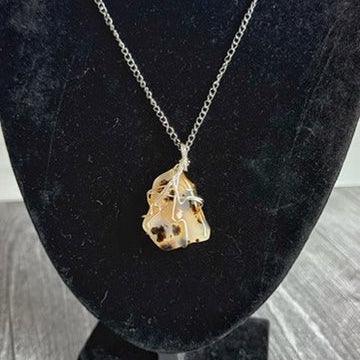 Gold necklace with a pendant on a black stand