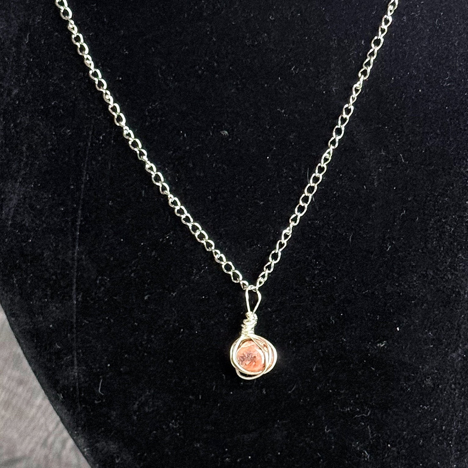 Necklace with a pendant on a black velvet stand