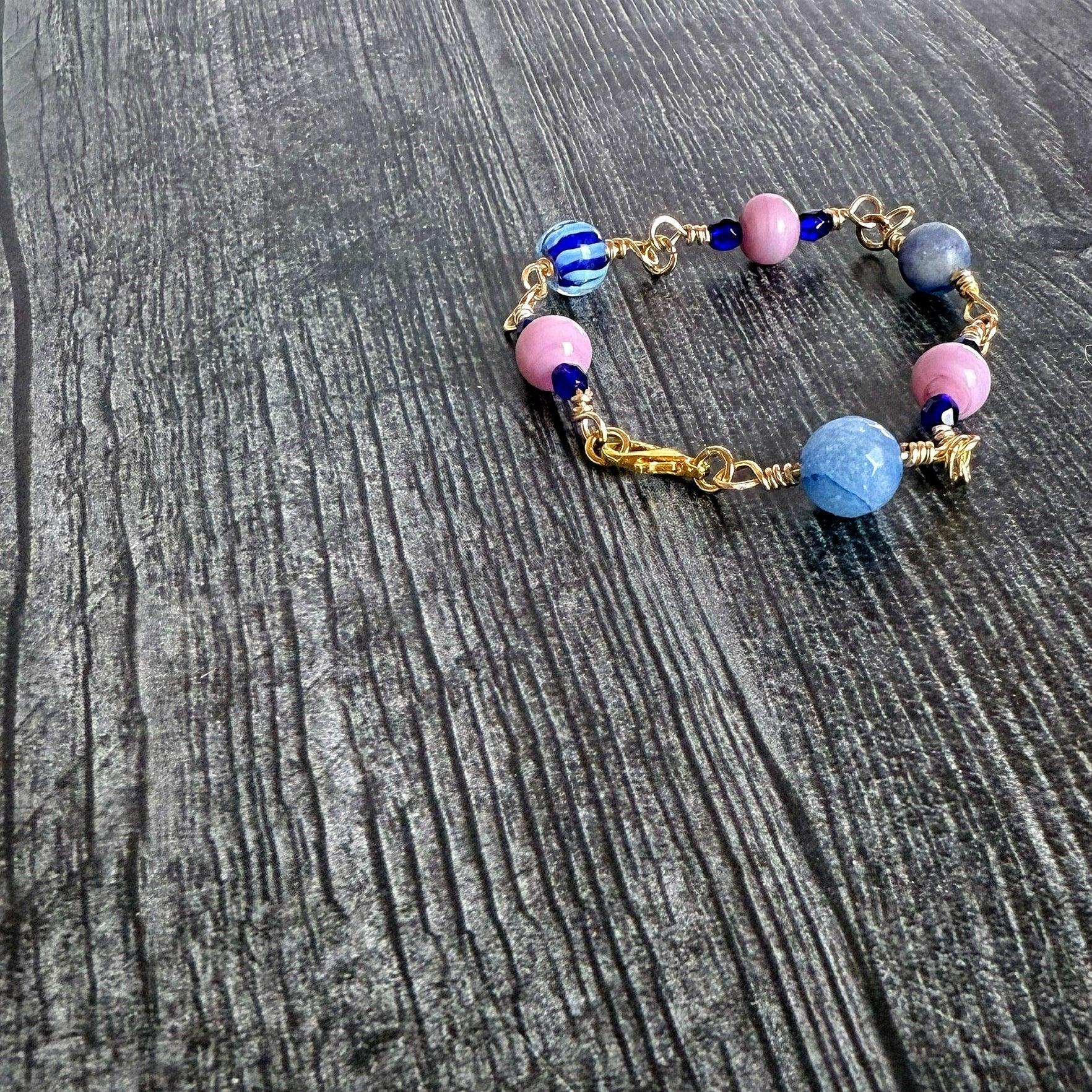 Bracelet with pink and blue beads on a wooden surface