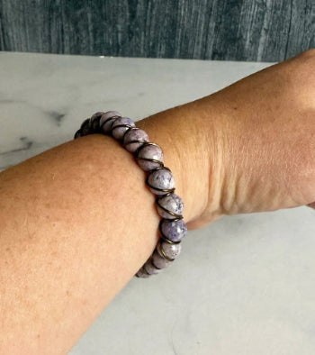 Beaded bracelet on a wrist with a neutral background