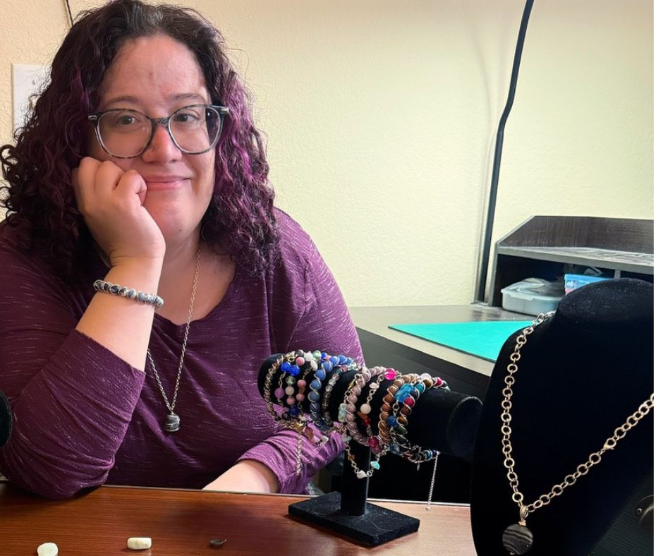 Person sitting at a desk with jewelry on display