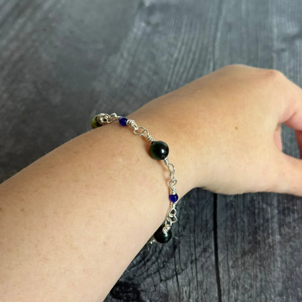 Bracelet with blue and blue beads on a wrist against a wooden background