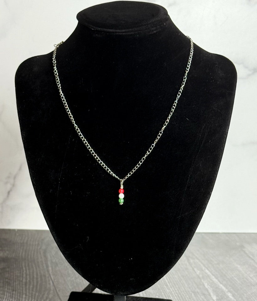 Necklace with a pendant on a black velvet mannequin bust against a white marble background