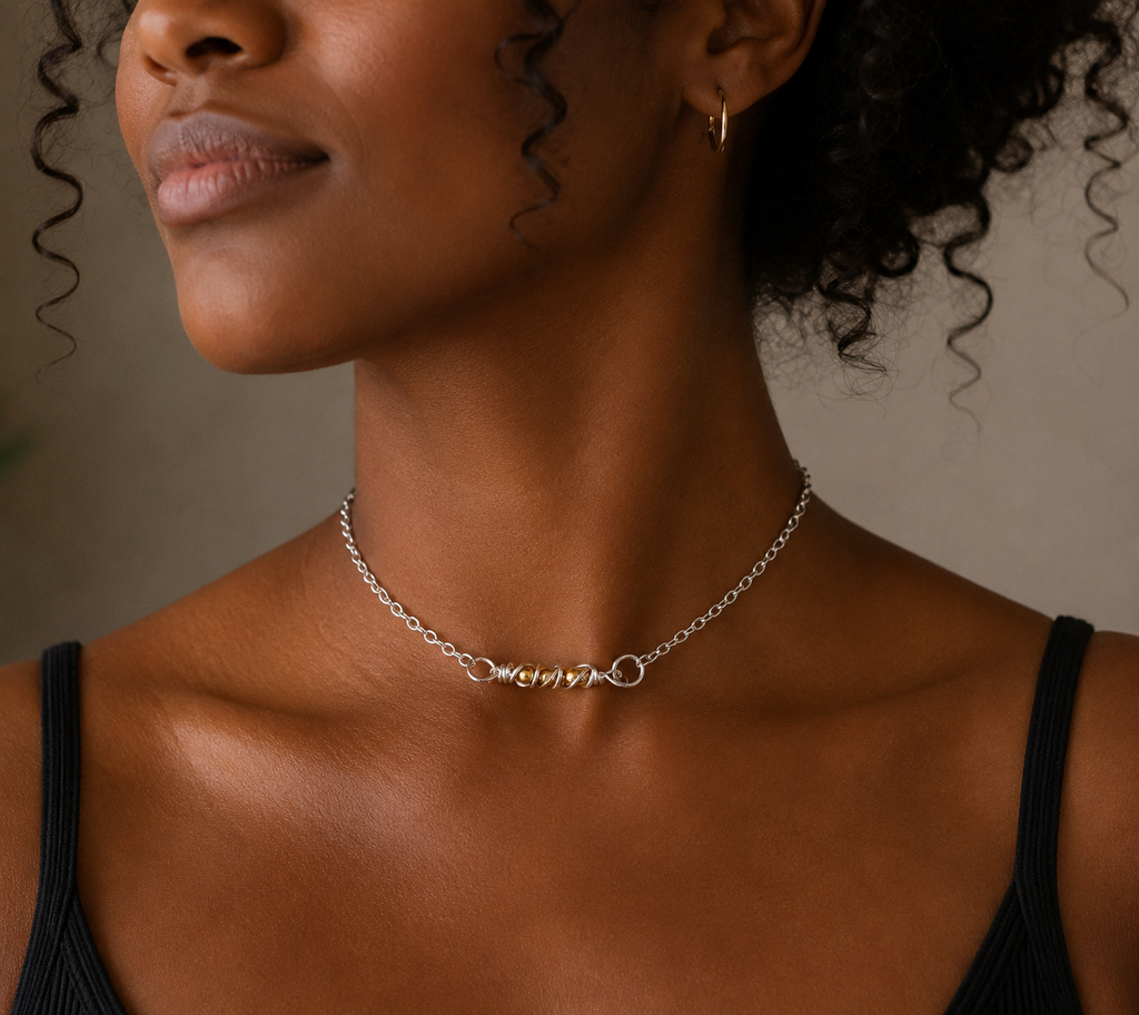 Close-up of a woman wearing a silver necklace against a neutral background