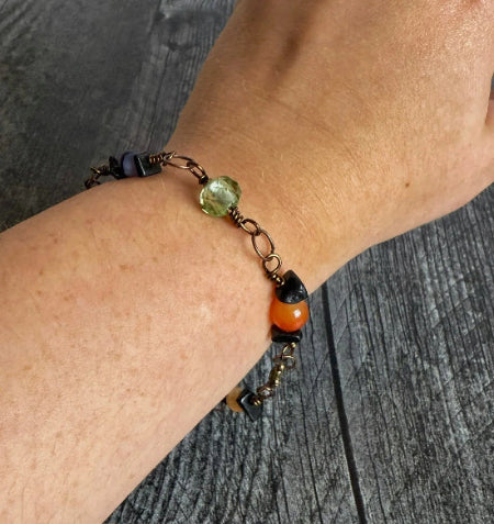 Close-up of a wrist wearing a beaded bracelet on a wooden surface