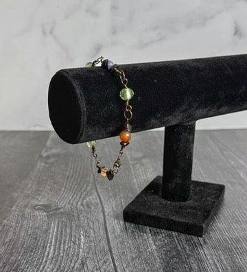 Bracelet with beads on a black velvet stand against a gray background