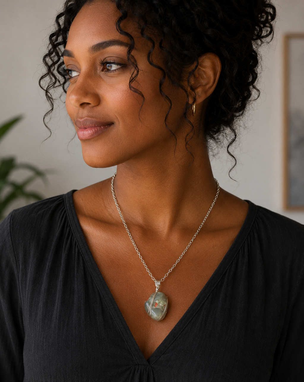 Woman wearing a necklace with a pendant indoors