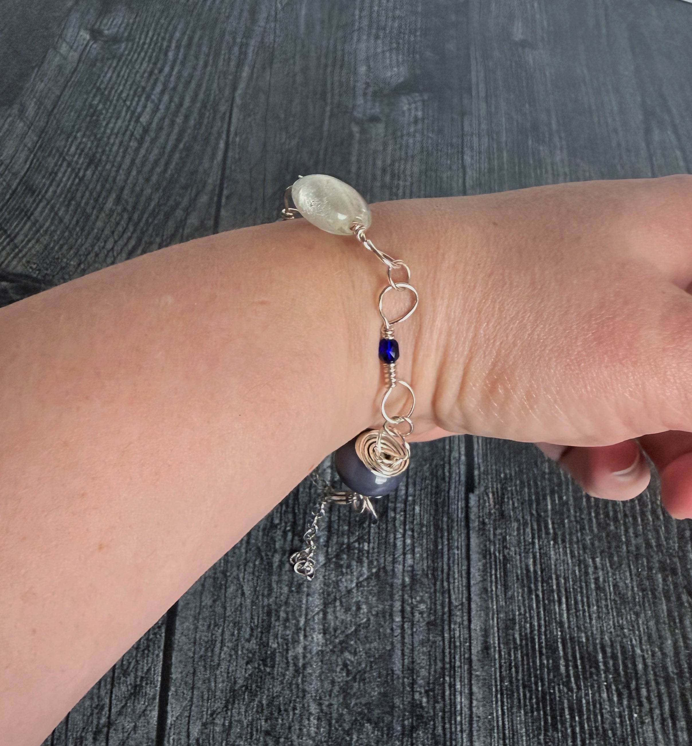 Bracelet with decorative elements on a wrist against a dark textured background
