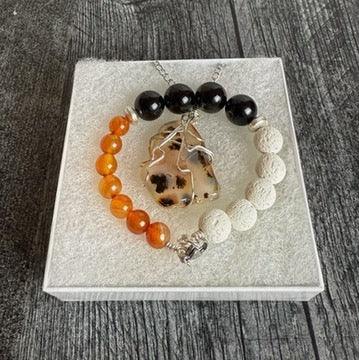 Set of a beaded bracelet and a necklace on a white box with a wooden background