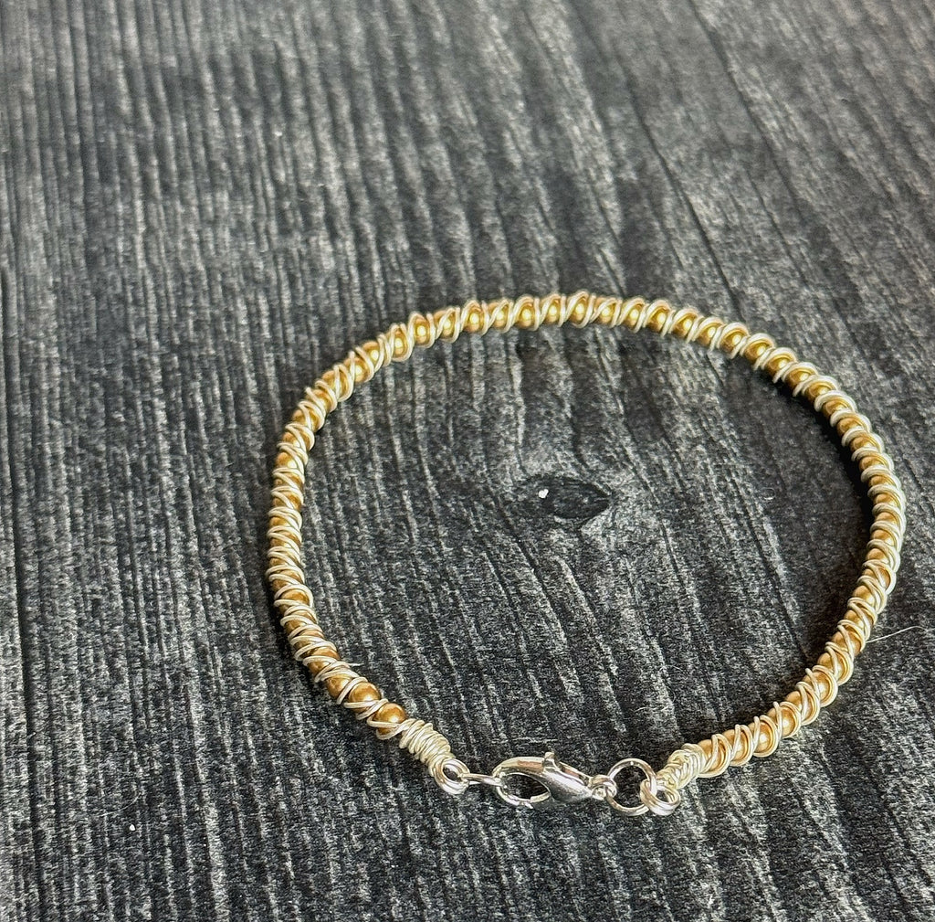 Gold beaded bracelet on a wooden surface