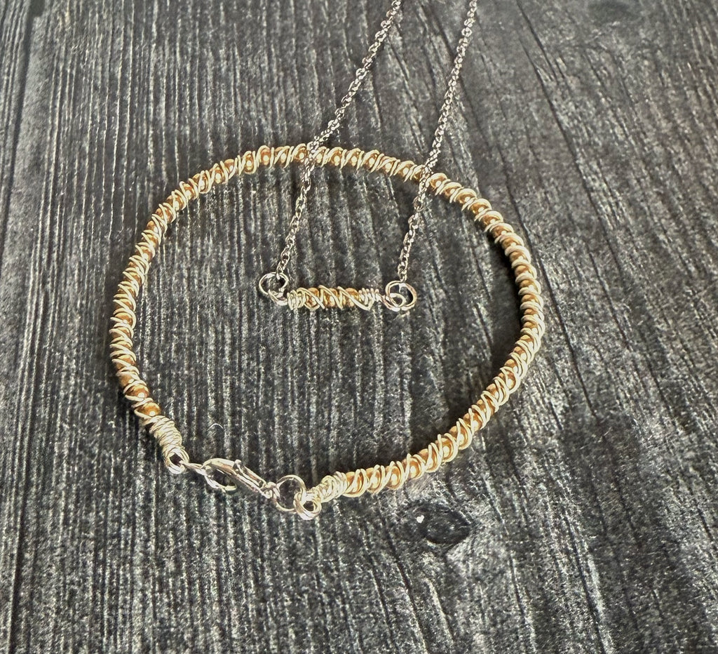 Gold beaded necklace on a textured gray surface