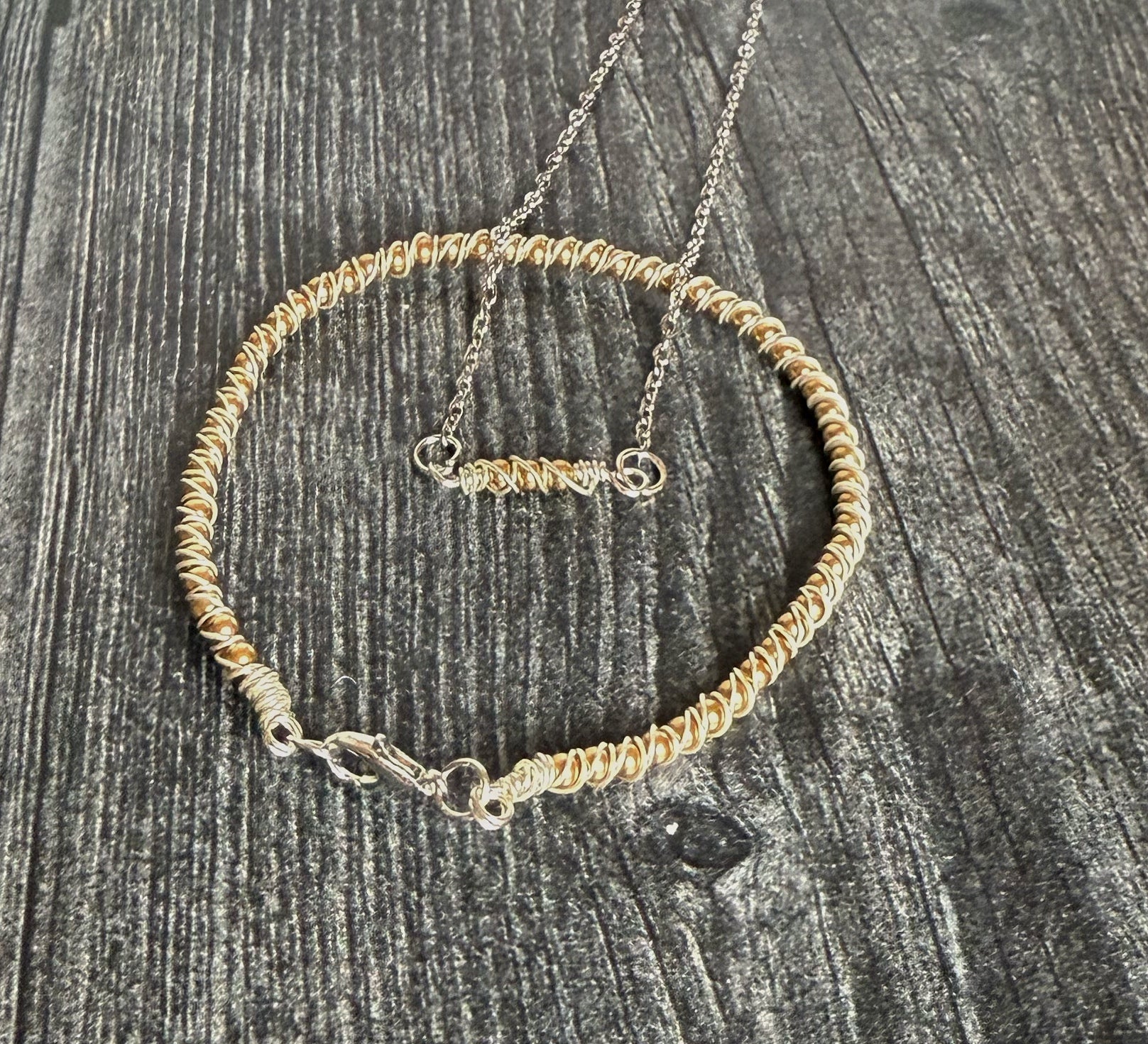 Gold beaded necklace on a textured gray surface