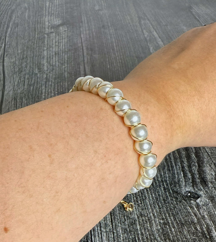 Pearl bracelet on a wrist with a wooden background