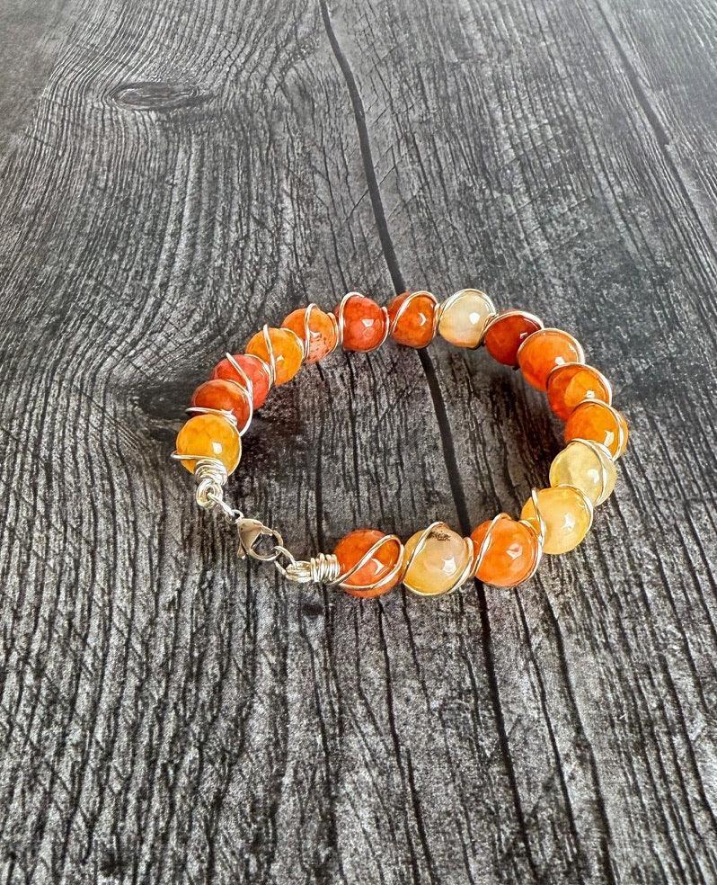 Bracelet with orange and yellow beads on a wooden surface