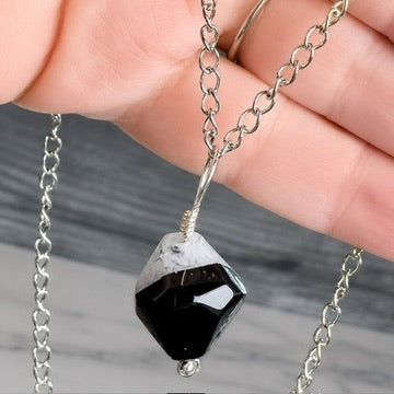 black a grey beaded pendant necklace in hand