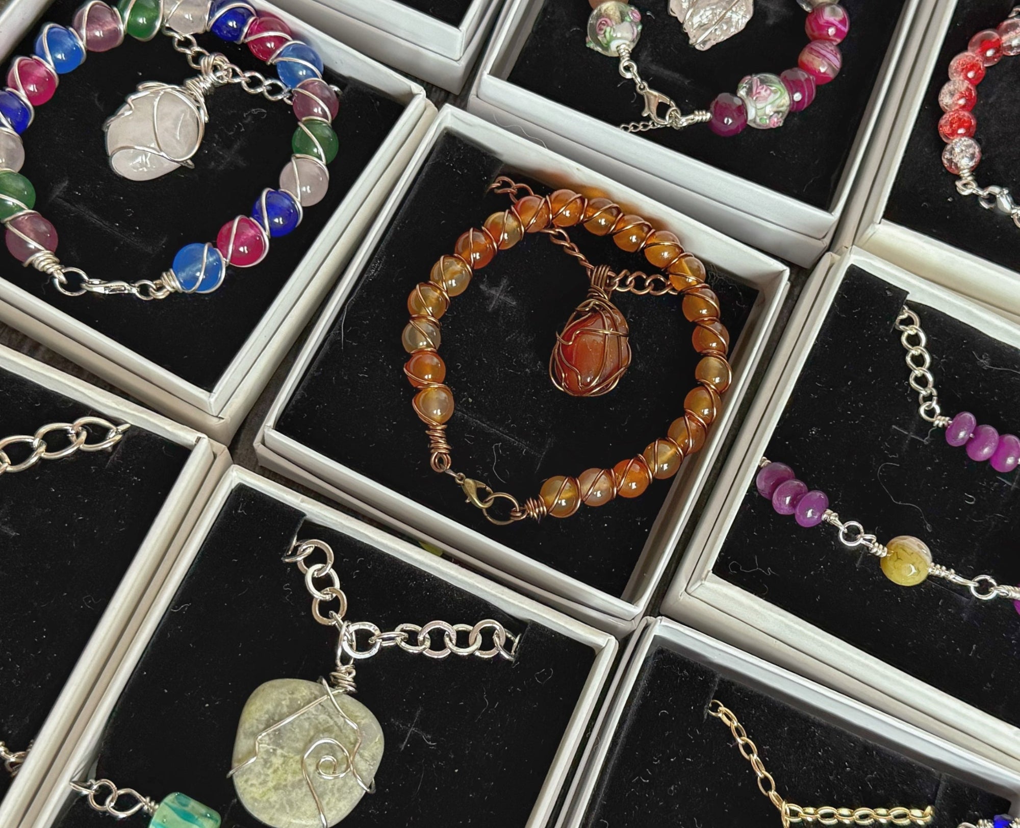 Collection of beaded and chain bracelets and necklaces in display boxes